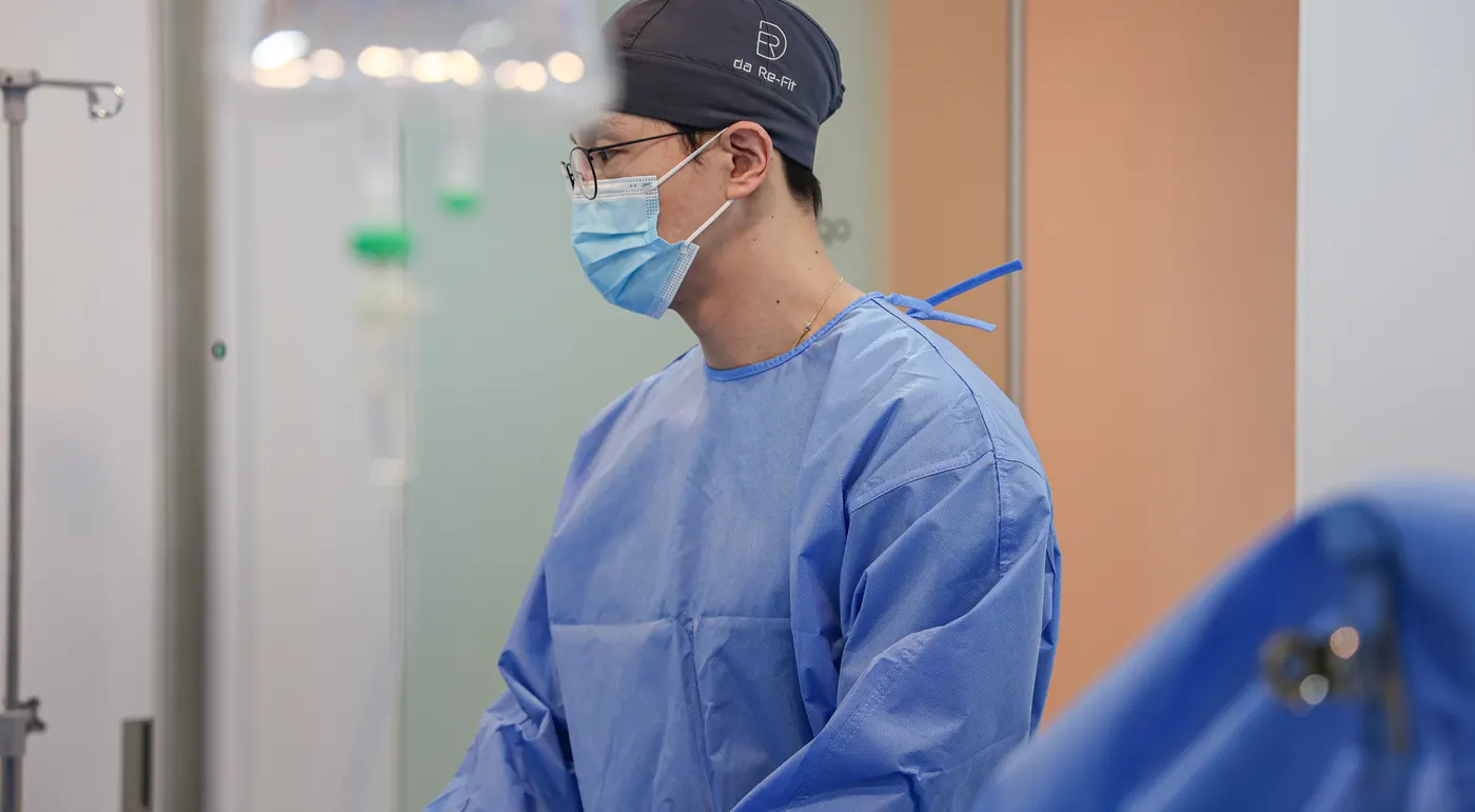 다리핏의원 진료실에서 도플러 초음파 프로브로 환자의 종아리 혈관을 검사하는 근접 장면